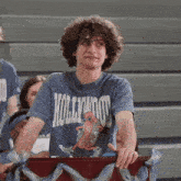 a young man wearing a blue hollywood t-shirt with a hot dog on it