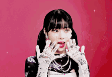 a girl with tattoos on her hands is wearing gloves and a necklace