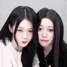 two girls with long black hair are posing for a photo
