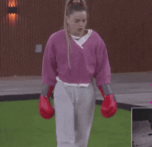 a woman wearing boxing gloves and a pink shirt