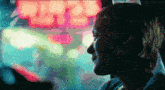a woman in a car looking out the window at a neon sign that says ' chinese ' on it