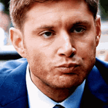 a man in a suit and tie making a face