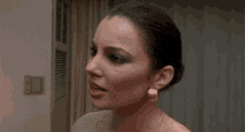 a woman is looking at herself in the mirror and making a funny face .