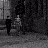a group of people are walking down a street .