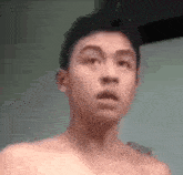 a shirtless man is making a surprised face