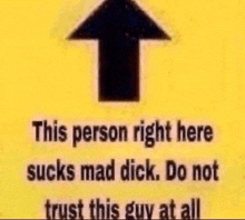 a yellow sign that says `` this person right here sucks mad dick . do not trust this guy at all '' .