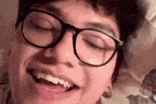 a close up of a person wearing glasses with their eyes closed .