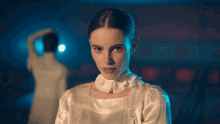 a woman in a white dress stands in front of a man in a white dress