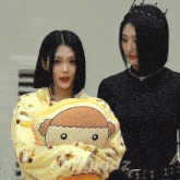 a girl with a crown on her head is holding a stuffed animal