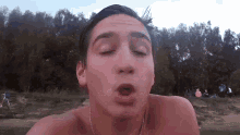 a shirtless man is making a funny face with his eyes closed