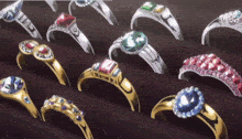 a bunch of rings on a table with one that has a blue stone
