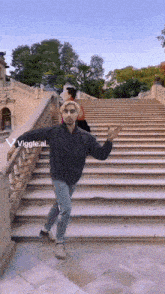 a man is dancing on a set of stairs with the letters viggle.ai visible in the corner