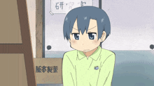 a boy in a green shirt is sitting in front of a box with chinese writing on it
