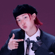 a man in a suit and tie is pointing at something with his finger .