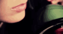 a close up of a woman 's mouth with a green object in her mouth .