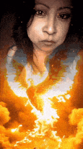 a woman 's face is surrounded by flames and a phoenix 's wings