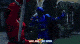 a red superhero is holding a torch with the words you are the king on the bottom