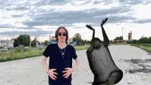 a man wearing sunglasses and a black shirt is standing in front of a frog