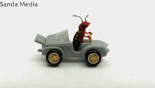 a toy car with an ant sitting in the driver 's seat and the words sanda media above it