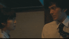 a man and a woman are looking at each other in a dark room .