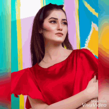 a woman in a red dress is standing in front of a colorful background made with vivavideo