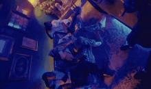 a group of people are laying on a couch in a dark room with blue lights