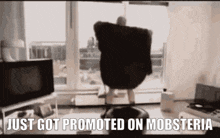 a man is dancing in a living room with the words `` just got promoted on mobsteria ''
