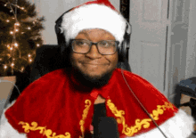 a man wearing a santa hat and a cape is smiling
