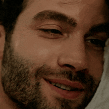 a close up of a man 's face with a beard