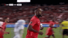a soccer player in a red jersey is running on the field