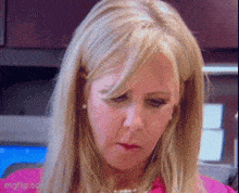 a close up of a woman 's face with a pink shirt