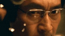 a close up of a man wearing glasses and a hat
