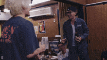 a man wearing a blue shirt with the word snoopy on the back is talking to another man