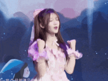 a girl in a pink dress with a bow on her hair