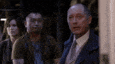 a man in a suit and tie stands next to a woman in a dark room