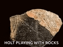 a close up of a rock with the words holt playing with rocks on it
