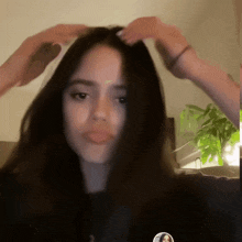 a woman with long dark hair is being brushed by someone