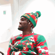 a man wearing a red and green sweater and a hat that says ' clippers ' on it