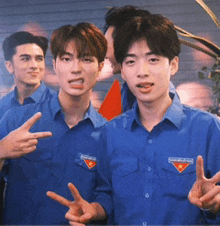 a group of young men wearing blue shirts with a triangle emblem on them