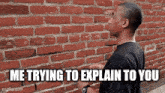 a man is standing in front of a brick wall .