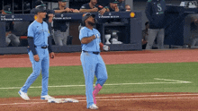 two blue jays players walking on the field