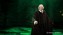 a man in a black robe is holding a green light