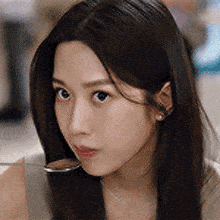 a close up of a woman with long hair looking at the camera .