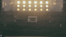 a blurred image of a stage with the letter d in the corner