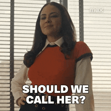 a woman is standing in front of a window and saying should we call her ?