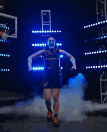a female basketball player wearing a black jersey with the word indian on it
