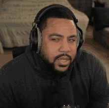 a man with a beard wearing headphones and a black shirt