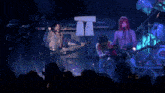a group of people playing instruments on a stage with marshall amps in the background