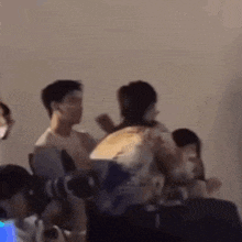 a group of people are sitting in a room and a man is standing in the middle of the room .