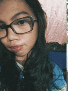 a young girl wearing glasses and a blue shirt